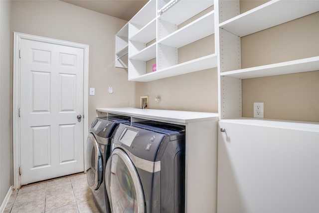 clothes washing area with laundry area, washing machine and dryer, and light tile patterned flooring