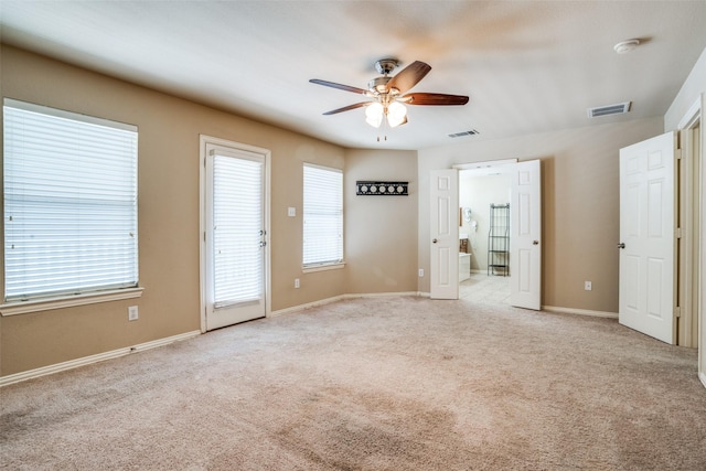 unfurnished room with a ceiling fan, carpet, visible vents, and baseboards