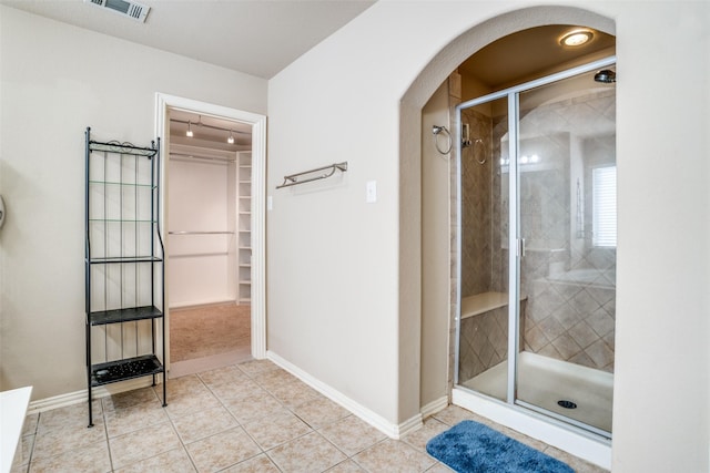 full bath with a stall shower, baseboards, visible vents, and tile patterned floors