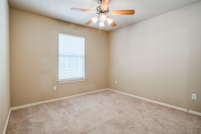 spare room with carpet floors, baseboards, and a ceiling fan