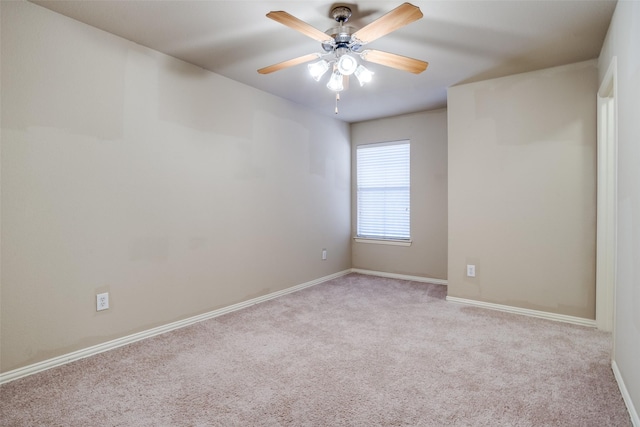 carpeted spare room with ceiling fan and baseboards