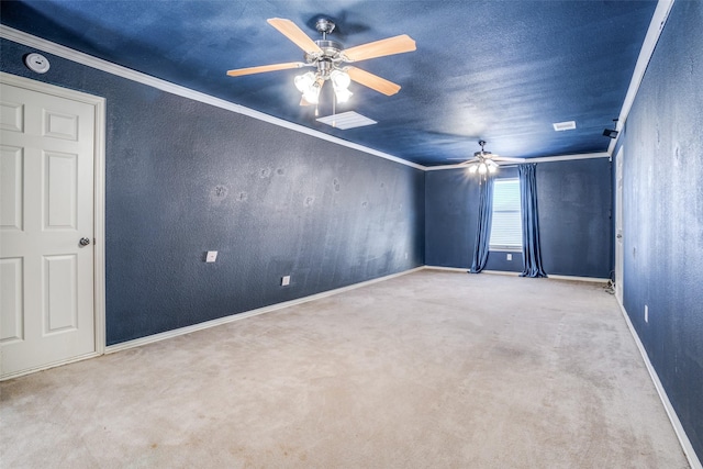 carpeted empty room with ornamental molding, a textured wall, ceiling fan, and baseboards