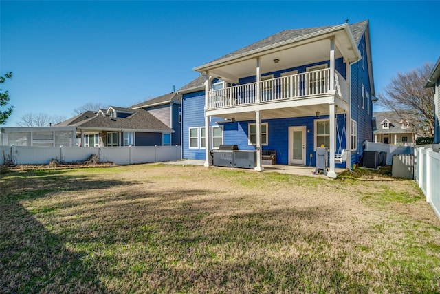 rear view of property with a lawn, a patio, a balcony, a fenced backyard, and cooling unit