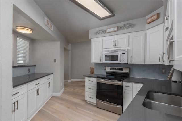 676 Harbor Dr, Azle, TX 76020 - kitchen with electric range, white microwave, dark countertops, backsplash, and white cabinets