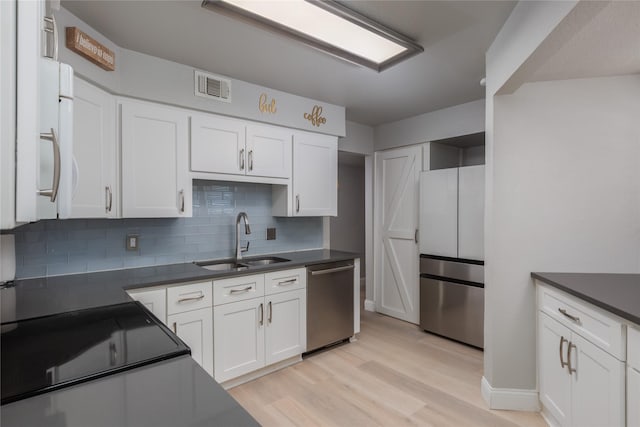 676 Harbor Dr, Azle, TX 76020 - kitchen featuring appliances with stainless steel finishes, a sink, white cabinetry, backsplash, and light wood-style flooring
