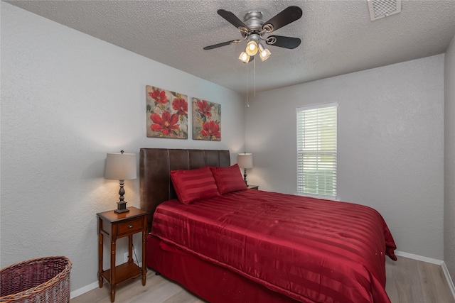 676 Harbor Dr, Azle, TX 76020 - bedroom featuring wood finished floors, baseboards, a textured ceiling, and ceiling fan