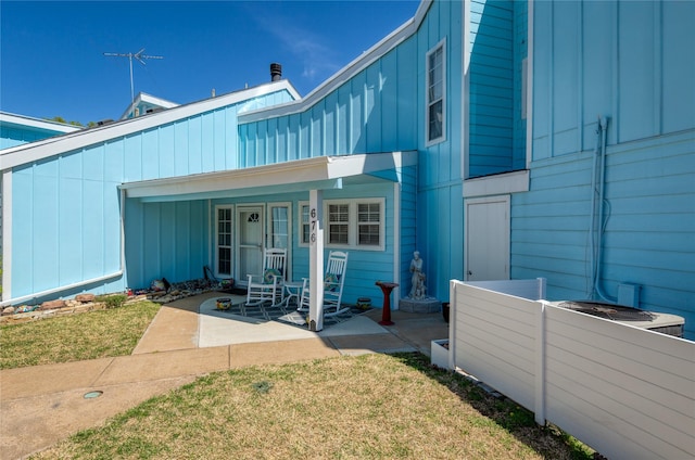 676 Harbor Dr, Azle, TX 76020 - back of house with board and batten siding, a lawn, and covered porch
