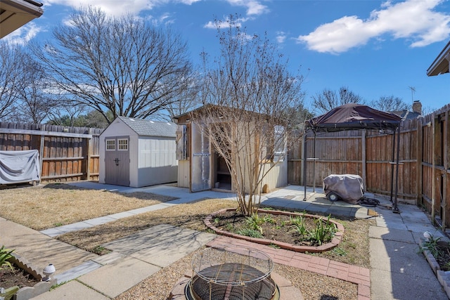 view of yard featuring a patio area, a shed, a fenced backyard, and an outdoor structure