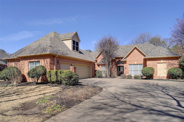 view of front of home with a shingled roof, brick siding, and driveway