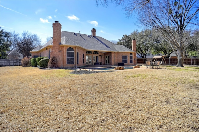 rear view of property featuring a patio area, brick siding, and fence