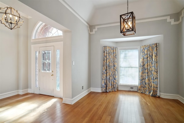 entrance foyer with a chandelier, wood-type flooring, and baseboards