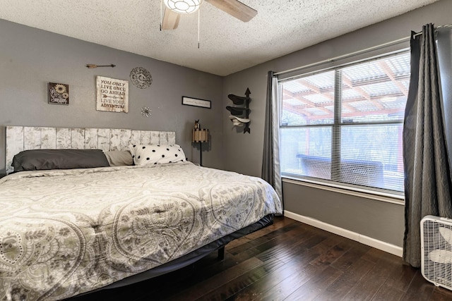 bedroom featuring dark wood-style flooring, ceiling fan, a textured ceiling, and baseboards