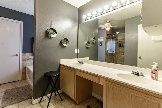 full bath featuring a garden tub, tiled shower, a sink, and tile patterned floors