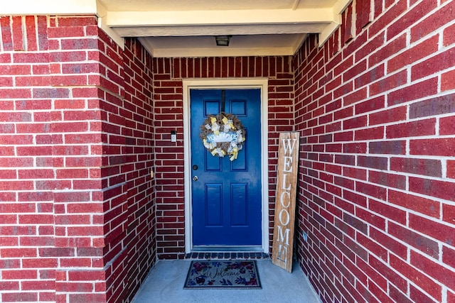 doorway to property with brick siding