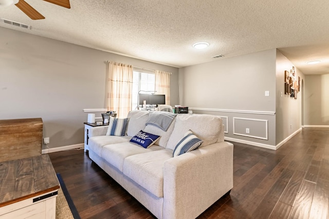 living room with wood finished floors, visible vents, and a ceiling fan