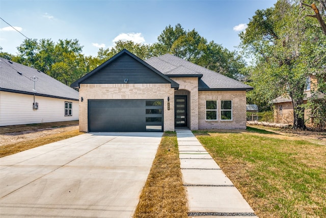 view of front facade featuring brick siding, a shingled roof, concrete driveway, an attached garage, and a front lawn