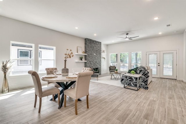 dining area with visible vents, wood tiled floor, french doors, a fireplace, and recessed lighting