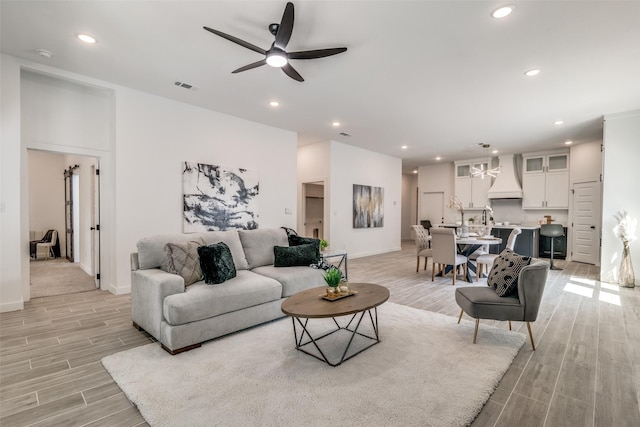 living area with ceiling fan, wood tiled floor, visible vents, and recessed lighting