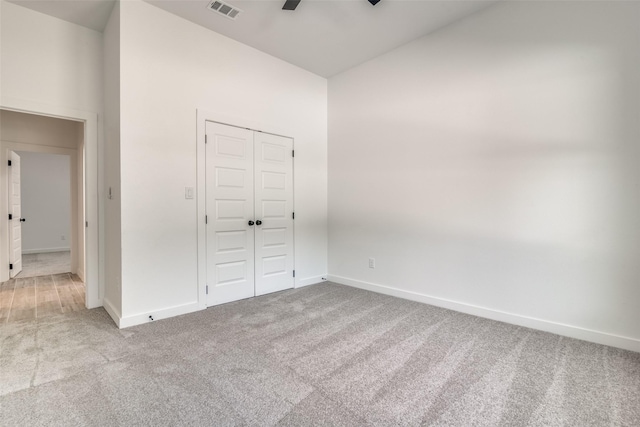 unfurnished bedroom featuring carpet, a closet, visible vents, and baseboards