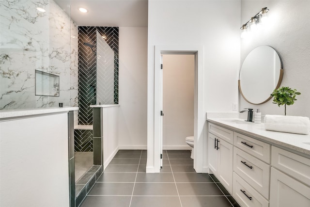 bathroom featuring baseboards, toilet, tile patterned floors, vanity, and a walk in shower