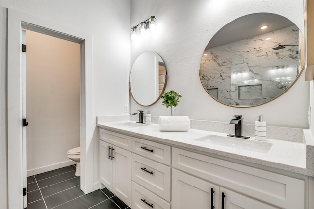 bathroom with toilet, tile patterned flooring, a marble finish shower, and a sink