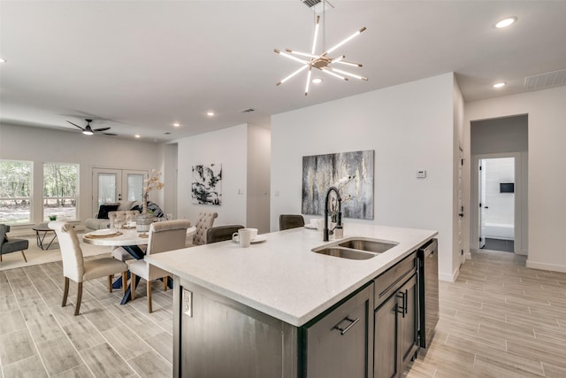 kitchen with recessed lighting, wood finish floors, a sink, open floor plan, and an island with sink