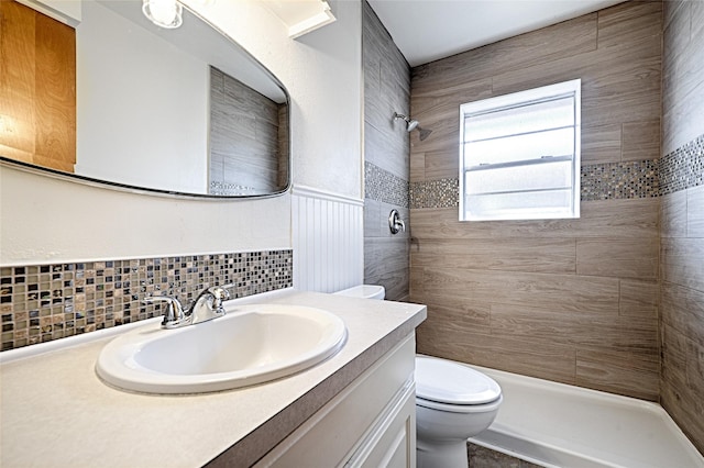 full bath with decorative backsplash, a shower stall, toilet, and vanity