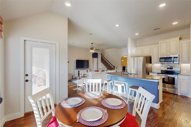 dining space featuring arched walkways, recessed lighting, visible vents, dark wood-type flooring, and ceiling fan