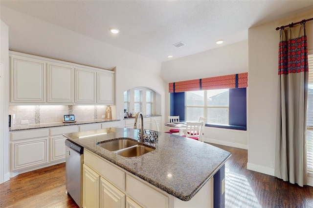 kitchen with a sink, visible vents, stainless steel dishwasher, tasteful backsplash, and dark wood finished floors