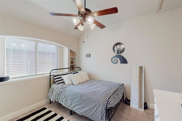 bedroom with light carpet, ceiling fan, baseboards, and vaulted ceiling