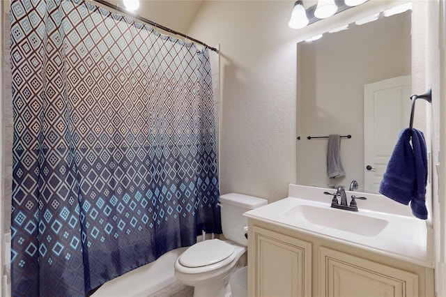 full bath with a textured wall, vanity, and toilet