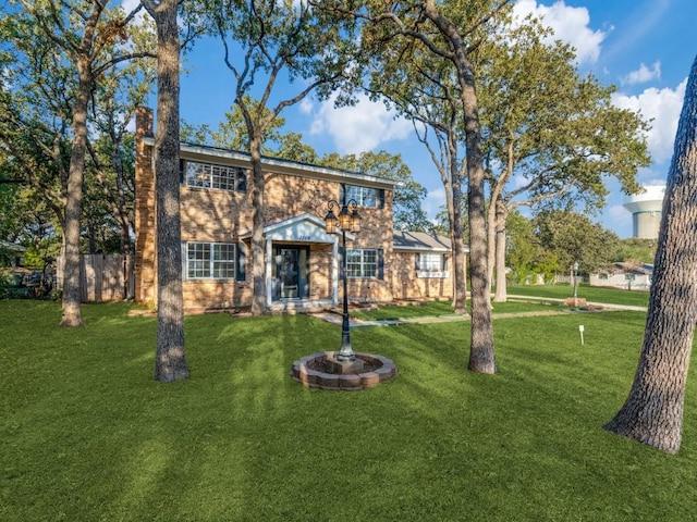 view of front of home featuring a chimney and a front lawn