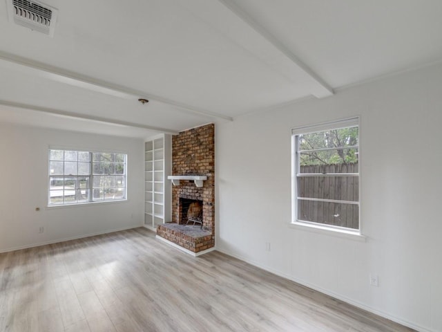 unfurnished living room featuring wood finished floors, visible vents, baseboards, a brick fireplace, and beam ceiling