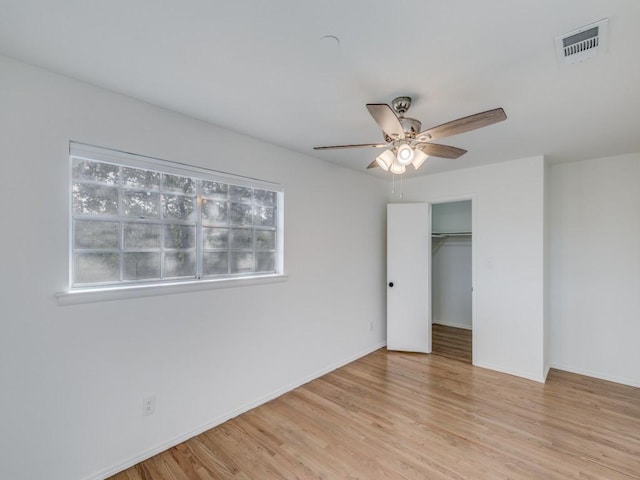 unfurnished bedroom with a ceiling fan, visible vents, baseboards, a closet, and light wood finished floors