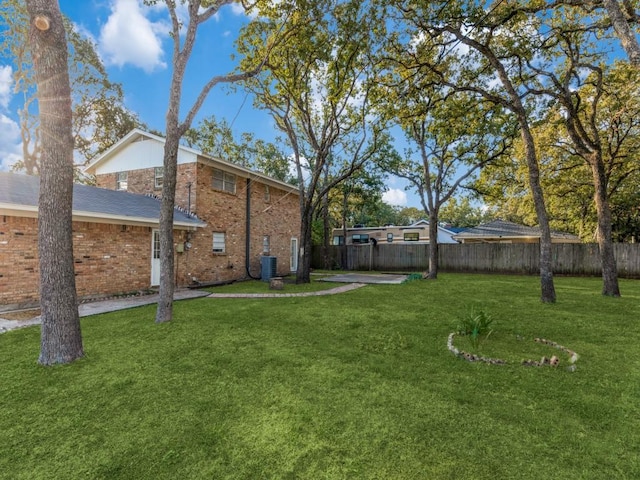 view of yard with central air condition unit and fence