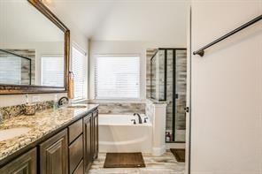 full bath with double vanity, a stall shower, a bath, lofted ceiling, and a sink