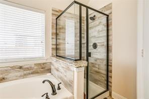 bathroom with a shower stall and a bath