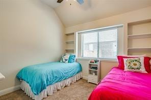 carpeted bedroom with vaulted ceiling, baseboards, and ceiling fan