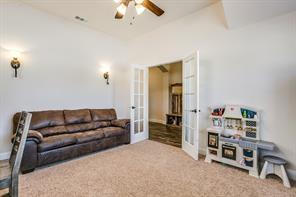 carpeted living room featuring vaulted ceiling, french doors, and a ceiling fan