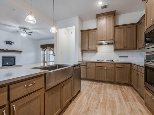 kitchen featuring visible vents, backsplash, appliances with stainless steel finishes, a sink, and under cabinet range hood