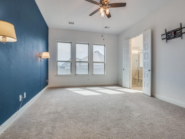 interior space featuring carpet floors, connected bathroom, visible vents, and baseboards