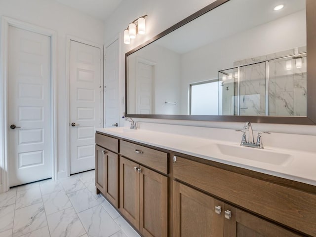 bathroom with double vanity, marble finish floor, a marble finish shower, and a sink