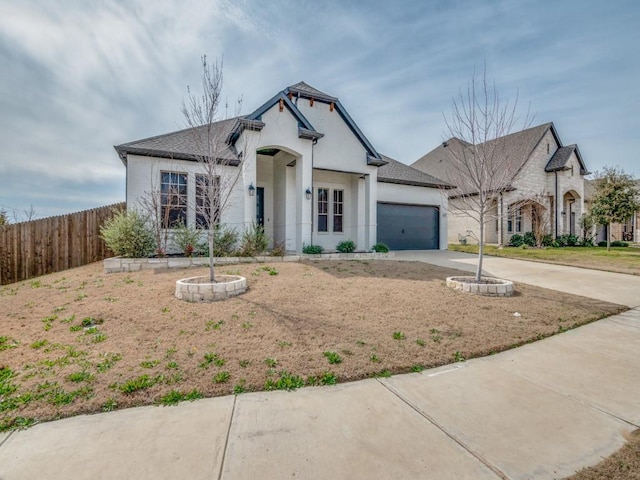 view of front of property featuring a garage, concrete driveway, and fence