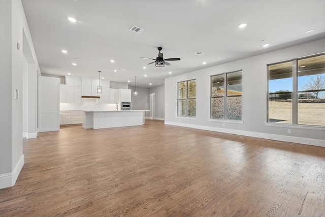 unfurnished living room featuring a ceiling fan, light wood-style flooring, recessed lighting, and baseboards
