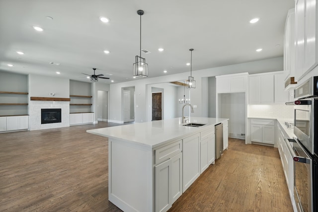 kitchen with ceiling fan, dishwasher, white cabinets, and a sink