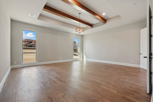 empty room featuring beam ceiling, a notable chandelier, visible vents, baseboards, and wood finished floors