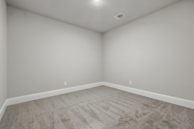 carpeted empty room featuring visible vents and baseboards