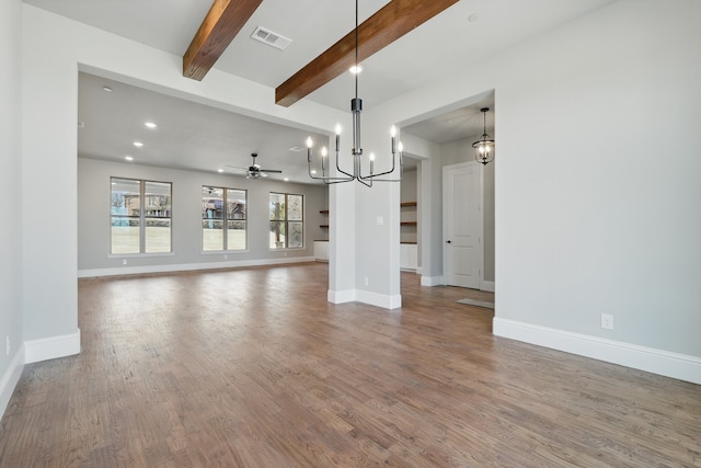 unfurnished living room featuring beam ceiling, wood finished floors, visible vents, and baseboards