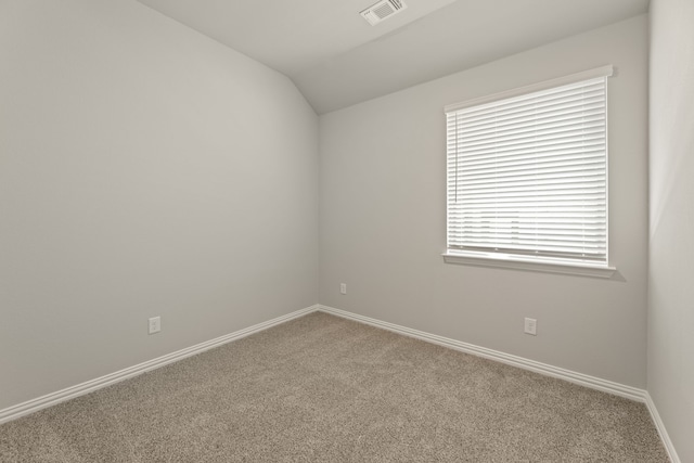 unfurnished room featuring carpet, visible vents, vaulted ceiling, and baseboards