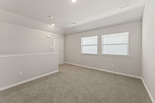 spare room with carpet, recessed lighting, visible vents, vaulted ceiling, and baseboards